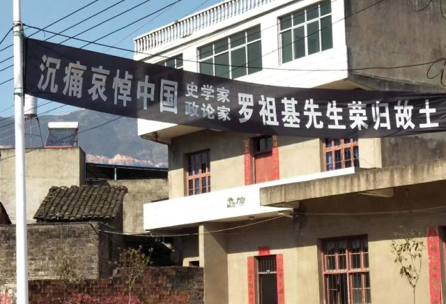 黑色横幅，上书“沉痛哀悼中国史学家、政论家罗祖基先生荣归故土”